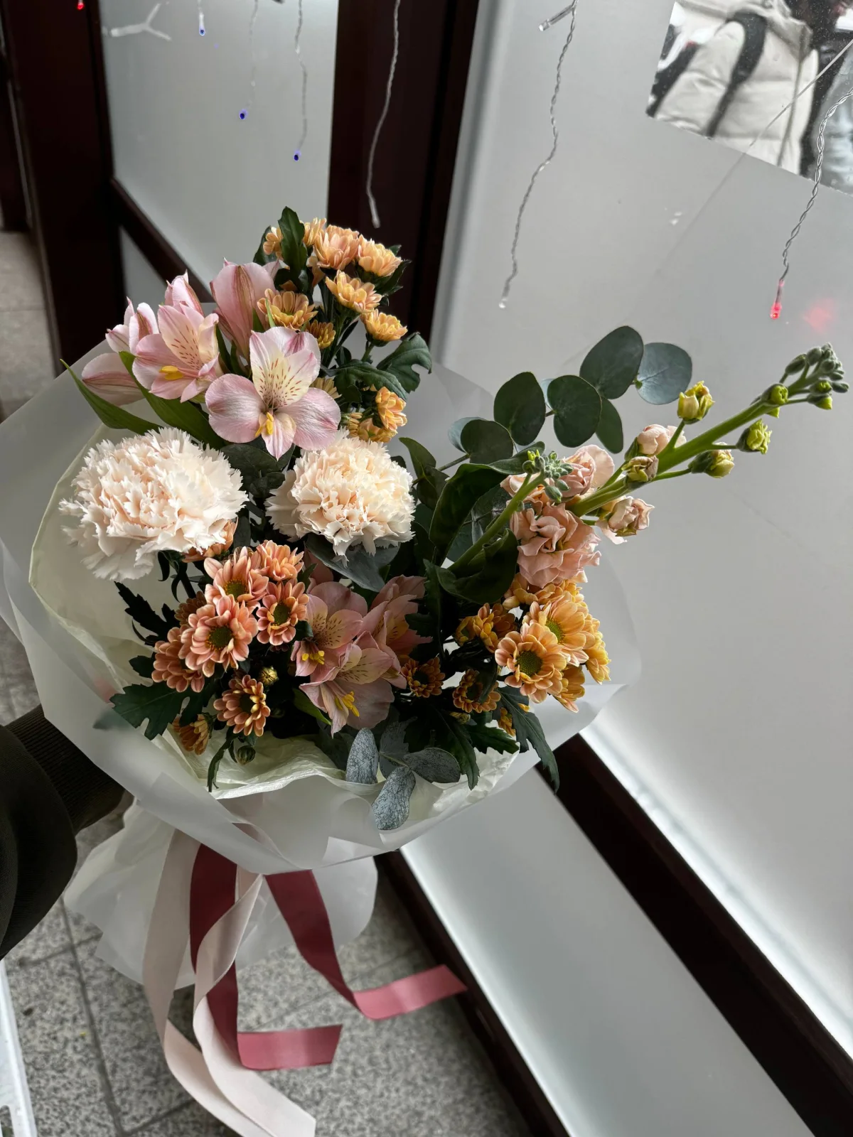 Букет с диантусами, альстромерией и эвкалиптом у окна